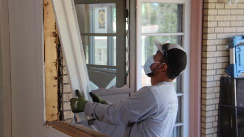 remodeler installing a window during covid-19