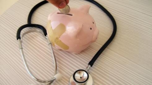Piggy bank and stethoscope denote health insurance costs rising.